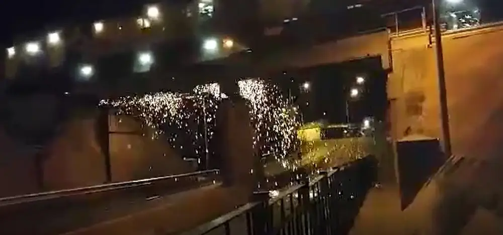 Sparks flying from a track grinding train at night.